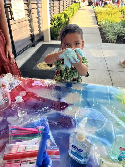 A child showing off his finished slime from Duran Fun Lab