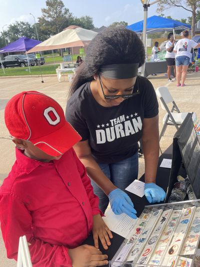 Duran Fun Lab artist helping a child choose a temporary tattoo at an event